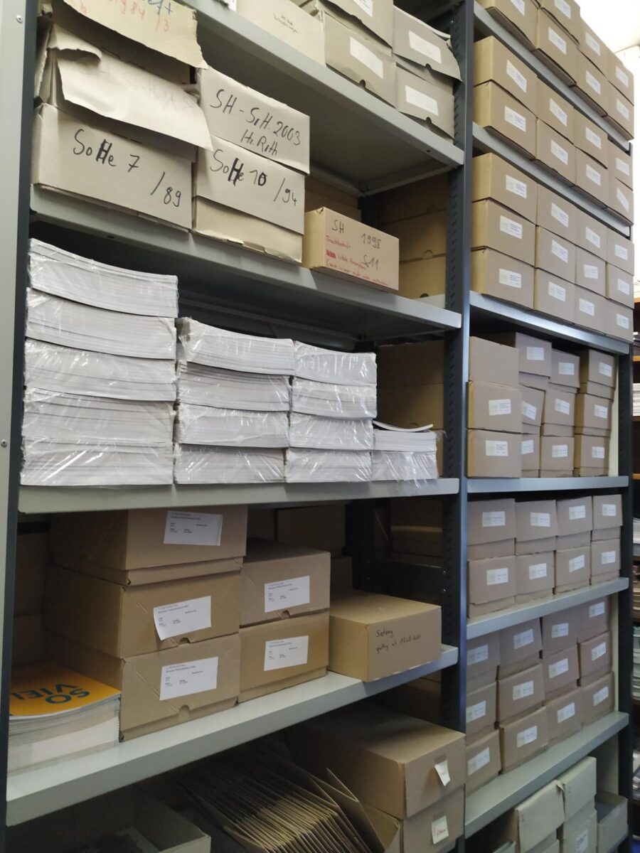 Regal mit Kartons und Papierstapeln