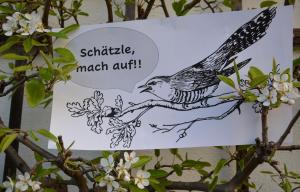 auf Plakat: im Comicstil sagt ein Vogel Schätzle, mach auf!