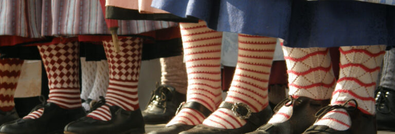 Beine mit Trachtenschuhe und bunten, gemusterten Socken