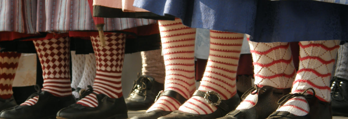 Beine mit Trachtenschuhe und bunten, gemusterten Socken